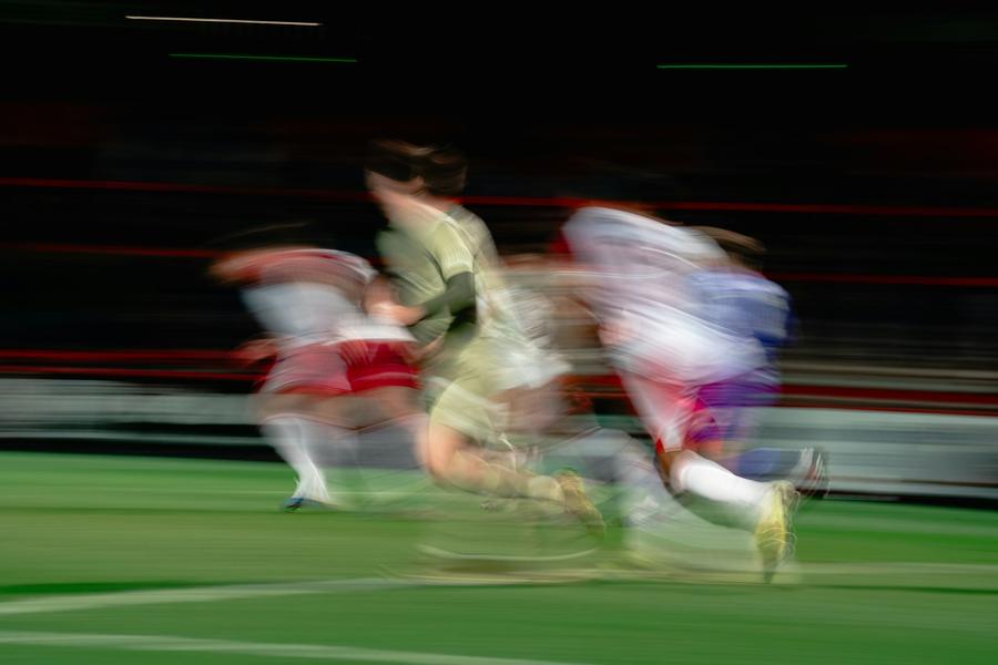 Hızla topa koşan oyuncular, hareket bulanıklığıyla